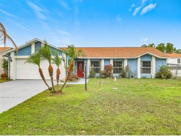 Cute blue house with a red door, two palm trees, and a well-maintained lawn at 936 Gillingham Ct, Kissimmee, FL 34758