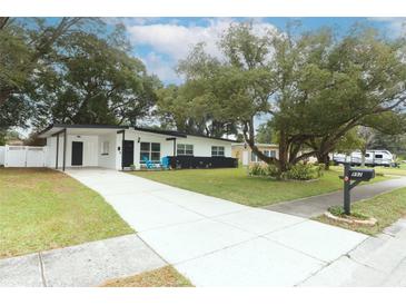 Mid-century modern home with landscaped yard, driveway, and updated exterior at 992 Carnation Dr, Winter Park, FL 32792
