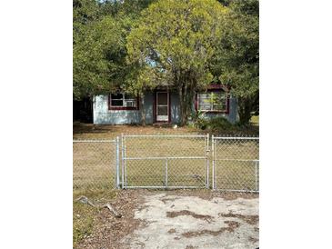 Ranch style home with chain link fence and mature trees at 1721 Grand St, Orlando, FL 32805