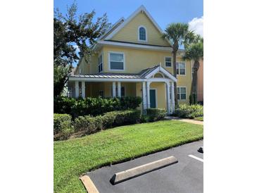 Charming yellow two-story home with a green door and well-maintained landscaping at 3006 Bonfire Beach Dr # 102, Kissimmee, FL 34746