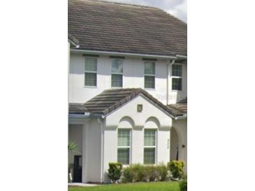 Charming townhome with white exterior, arched windows, and well-maintained landscaping at 430 Captiva Dr, Davenport, FL 33896