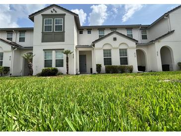 Well-maintained townhome with lush green lawn, tidy landscaping, and a gray front door at 430 Captiva Dr, Davenport, FL 33896