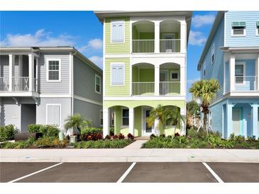 Three-story light green house with white accents and landscaping at 8049 Lost Shaker Ln, Kissimmee, FL 34747