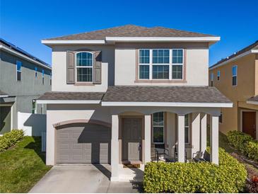 Two-story house with gray siding, two-car garage, and a front porch at 242 Aberdeen St, Davenport, FL 33896