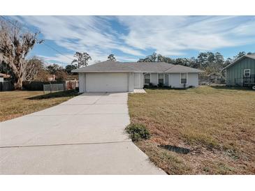 Single story home with attached garage and grassy yard at 4465 Ne 2Nd Ct, Ocala, FL 34479