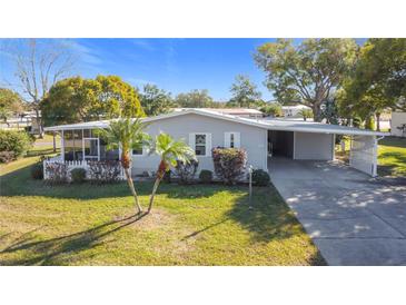 Single-story home with carport, landscaped lawn, and screened porch at 515 Tivoli Park Dr, Davenport, FL 33897