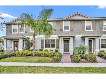 Gray townhome with brick pavers, landscaping, and palm tree at 10065 Salt Point Dr, Winter Garden, FL 34787