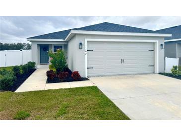 Newly constructed home with a two-car garage and well-manicured lawn at 1107 Tropea Ln, Auburndale, FL 33823