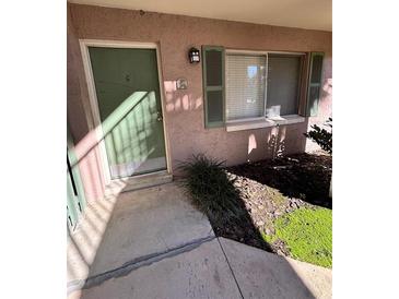 Exterior view of condo with green door, window, and landscaping at 122 Waterfront Way # 110, Altamonte Springs, FL 32701