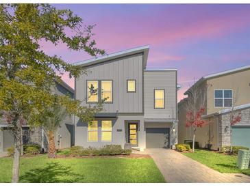 Modern two-story home with gray siding, a gray roof and a landscaped lawn at 2748 Bookmark Dr, Kissimmee, FL 34746