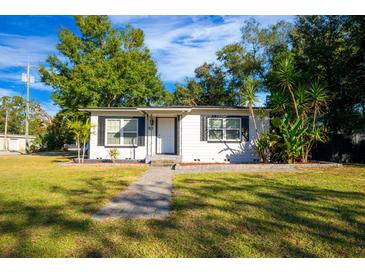 Charming home featuring a well-manicured lawn, inviting walkway, and tasteful landscaping at 2803 E Pine St, Orlando, FL 32803