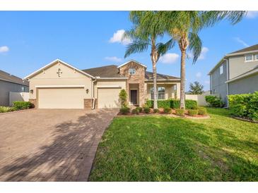 Two-story house with a three-car garage and landscaped lawn at 4032 Prairie Reserve Blvd, Orlando, FL 32824