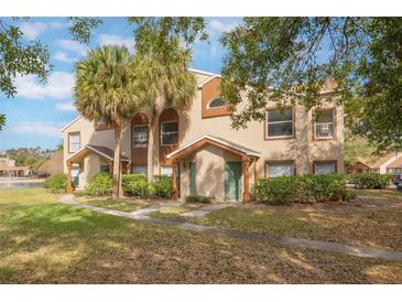 Two-story condo building with palm trees and grassy area at 5436 E Michigan St # 4, Orlando, FL 32812