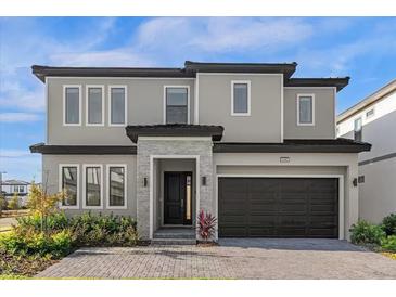 Two-story house with gray exterior, dark garage door, and stone accents at 6080 High Seas Dr, Orlando, FL 32821