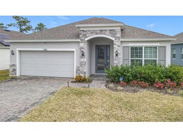 One-story home with stone accents and a two-car garage at 7051 Lanier Falls Rd, Deland, FL 32724