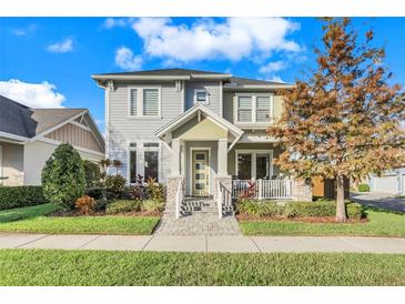 Two-story craftsman home with gray siding, stone accents, and a landscaped yard at 9085 Yonath St, Orlando, FL 32827