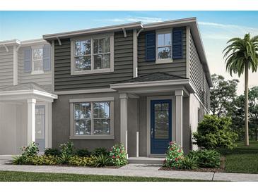 Two-story home with gray siding, blue door, and landscaping at 9843 Walkway Dr, Orlando, FL 32832