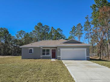 Newly constructed home with gray siding, red door, and a two-car garage at 406 Marion Oaks Pass, Ocala, FL 34473