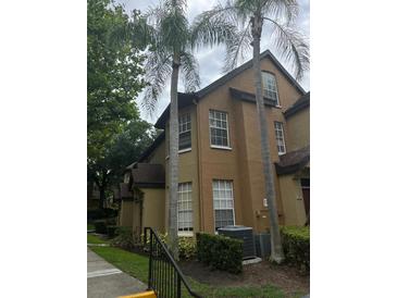 Two-story townhome with palm trees and landscaping at 6348 Raleigh St # 1311, Orlando, FL 32835