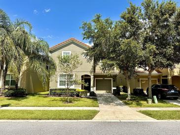 Two-story house with attached garage and landscaped yard at 8848 Candy Palm Rd, Kissimmee, FL 34747