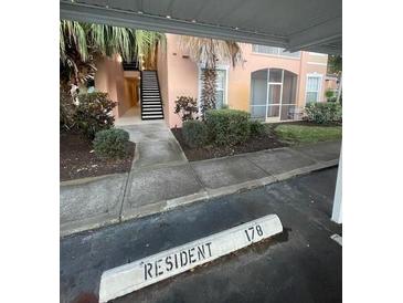 Condo building exterior with parking and walkway under tropical trees at 13560 Turtle Marsh Loop # 319, Orlando, FL 32837