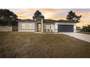 New construction home with gray garage door and landscaping at 2831 Sw 166Th Ln, Ocala, FL 34473