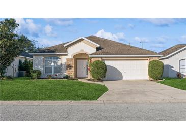 One-story house with a two-car garage and well-maintained lawn at 305 Therese St, Davenport, FL 33897