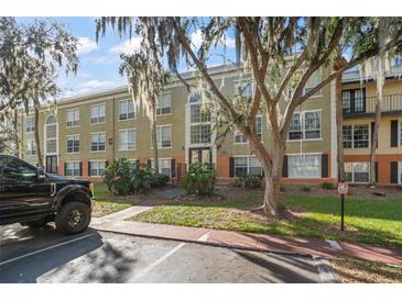 Exterior view of a condo building with landscaping and parking at 4172 Versailles Dr # 4172D, Orlando, FL 32808
