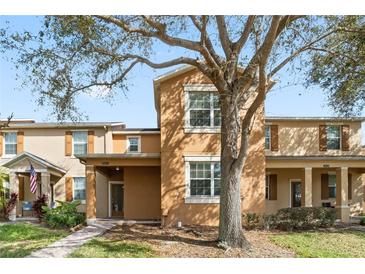 Charming townhouse featuring a well-maintained lawn and inviting front entryway at 9025 Savannah Julip Ln, Orlando, FL 32832