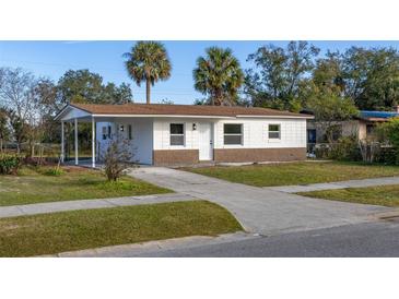 Newly renovated house with a carport and a well-maintained lawn at 128 Academy Ave, Sanford, FL 32771