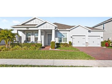 Gray house with a two-car garage and manicured lawn at 16719 Sanctuary Dr, Winter Garden, FL 34787