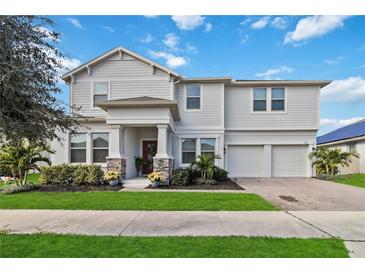 Two-story house with white siding, stone accents, and a two-car garage at 394 Singing Tree Ln, Winter Springs, FL 32708