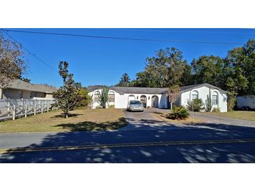 Single-story home with driveway, landscaping, and fenced yard at 547 Queens Mirror Cir, Casselberry, FL 32707