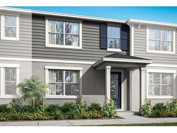Two-story townhome with gray siding, blue shutters, and landscaping at 9851 Walkway Dr, Orlando, FL 32832