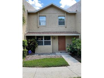 Two-story stucco home with a brown door and landscaping at 1009 Grove St # 90, Maitland, FL 32751