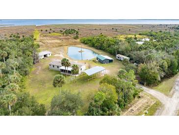 Aerial view of a home on a large lot with a pond, multiple buildings and waterfront access at 2570 Canvasback Trl, Geneva, FL 32732