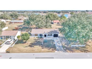Aerial view of a single-story house with a large yard and lake nearby at 37 Hickory Track Way, Ocala, FL 34472