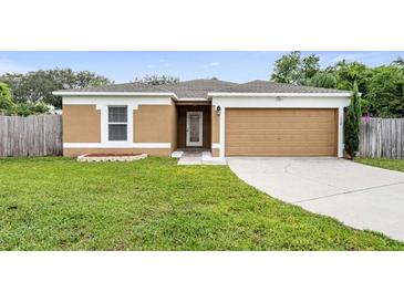 One-story house with a two-car garage and landscaped lawn at 1208 Honey Rd, Apopka, FL 32712