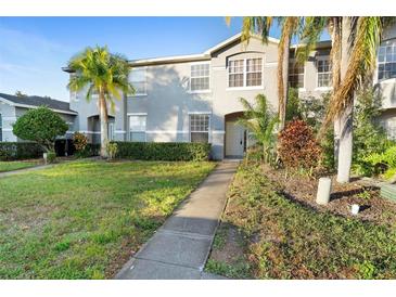 Two-story townhome with landscaped lawn and walkway at 13312 Summerton Dr, Orlando, FL 32824