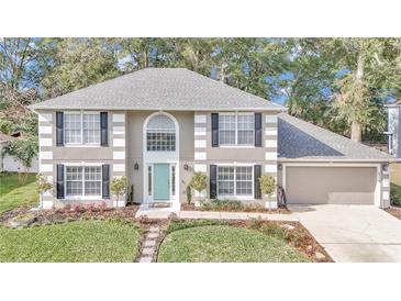 Two-story house with gray siding, black shutters, and a teal front door at 2718 Se 45Th Ave, Ocala, FL 34480