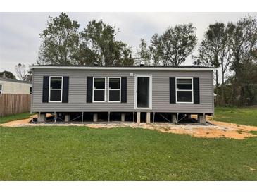 Gray manufactured home with black shutters, set on a grassy lot at 3548 Valley Trl, Lakeland, FL 33810