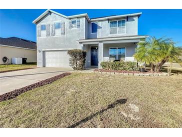 Two-story house with gray siding, blue door, and attached garage at 6163 Forest Ridge Way, Winter Haven, FL 33881