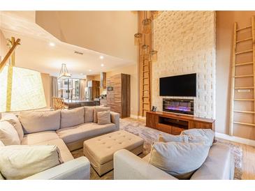 Open living area with sectional sofa, fireplace, and access to a patio at 7535 Brooklyn Dr, Kissimmee, FL 34747