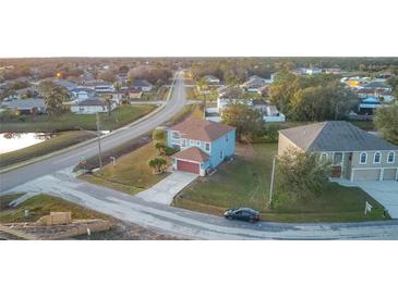 Aerial view of two-story house with attached garage, located in a residential neighborhood at 1001 Dampierre Ct, Kissimmee, FL 34759
