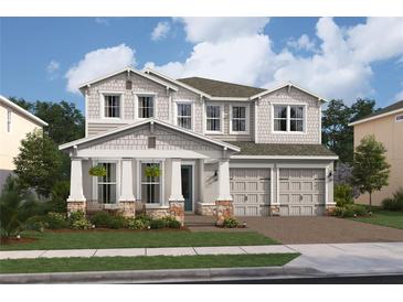 Two-story home with gray siding, stone accents, and a two-car garage at 13200 Faro Ct # 44, Winter Garden, FL 34787