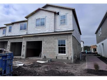 Two-story house under construction with two-car garage, block exterior, and landscaping at 5106 Rain Shadow Dr, Saint Cloud, FL 34772