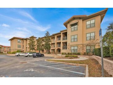 Tan colored building exterior with parking and landscaping at 914 Charo Pkwy # 113, Davenport, FL 33897