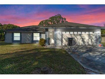 Single-story home with attached garage and landscaped yard at 9405 Holbrook Dr, Orlando, FL 32817