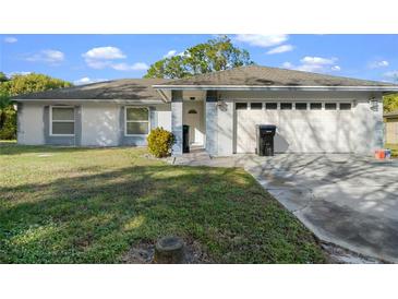 Charming single-story home featuring a well-maintained lawn, attached two-car garage, and inviting front entrance at 9405 Holbrook Dr, Orlando, FL 32817
