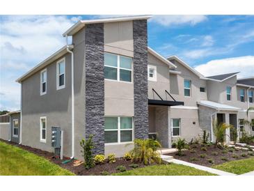 Modern two-story home with gray exterior and stone accents at 1176 Challenge Dr, Davenport, FL 33896